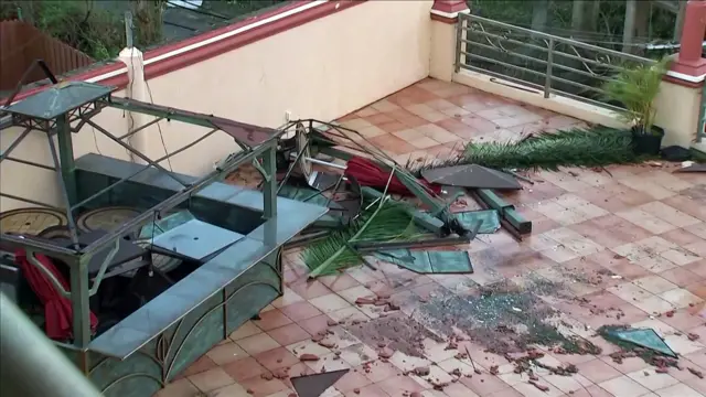 Shattered table and palm trees in a balcony in Montego Bay