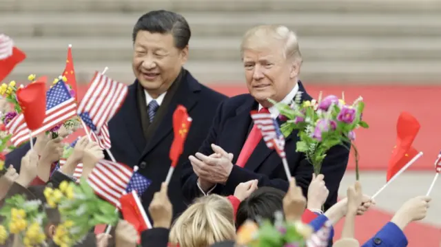 Xi Jinping and Donlad Trump approach flag-waving people