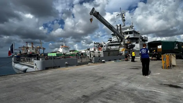 A boat is pictured with supplies onboard and a crane loading supplies onto the boat