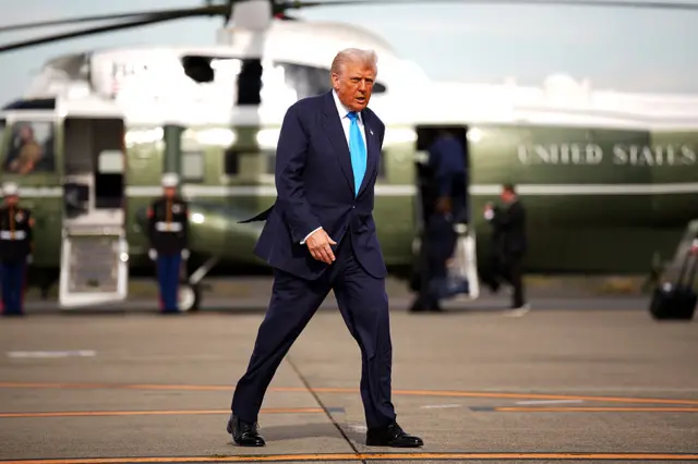 Donald Trump walking in front of a helicopter