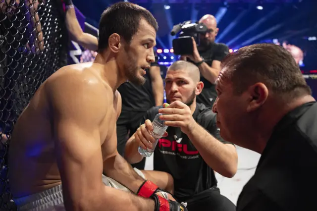 Usman Nurmagomedov is given water by Khabib Nurmagomedov in the corner between rounds