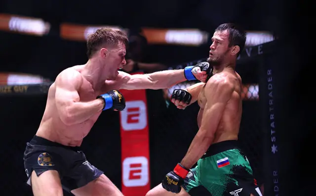 Paul Hughes throwing a straight left at Usman Nurmagomedov