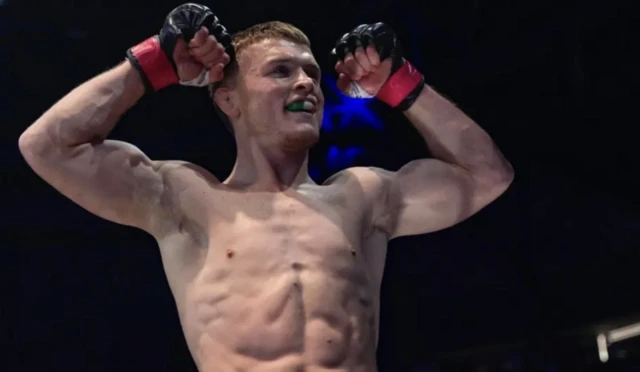 Paul Hughes flexing his biceps after winning