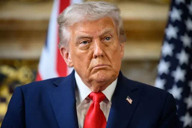 Donald Trump is pictured wearing a navy jacket and red tie