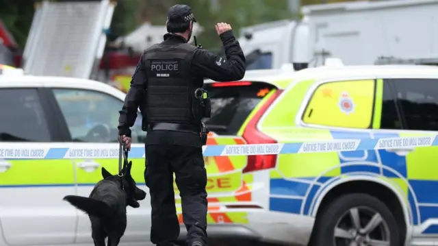 Police work with dogs at a cordoned off area in Manchester, Britain, 02 October 2025