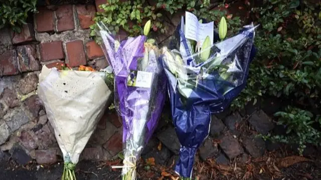 three bunches of flowers on a pavement