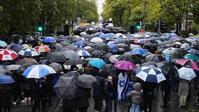 People attend a vigil near the scene at Heaton Park Hebrew Congregation synagogue