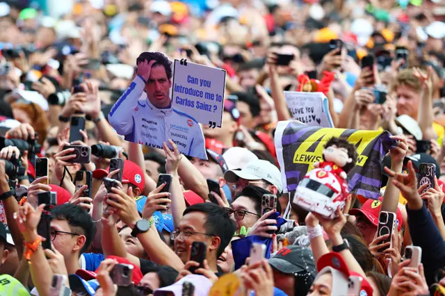 Fans hold up signs in the fanzone in Singapore