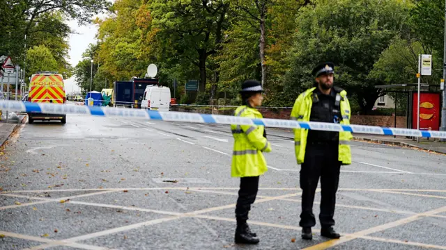 Two police officers stand in road near synagogue in Manchester