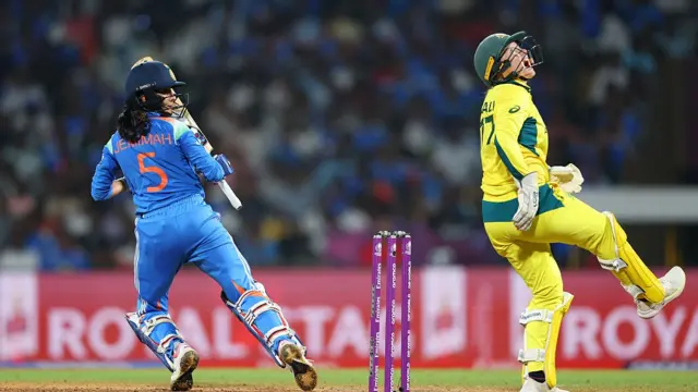 0: Wicket keeper Alyssa Healy of Australia reacts after being struck in the finger as Jemimah Rodrigues of India looks on during the ICC Women's Cricket World Cup India 2025 Semi-Final m