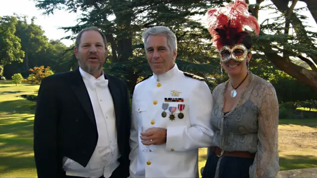 Harvey Weinstein in black tailcoat (L), Jeffrey Epstein in a US Navy suit holding a glass (C) and Ghislaine Maxwell in a fancy Venetian-style mask with red feathers, a semi-clear top with a black spaghetti-strap top and jeans. They're posing in a garden in front of some trees