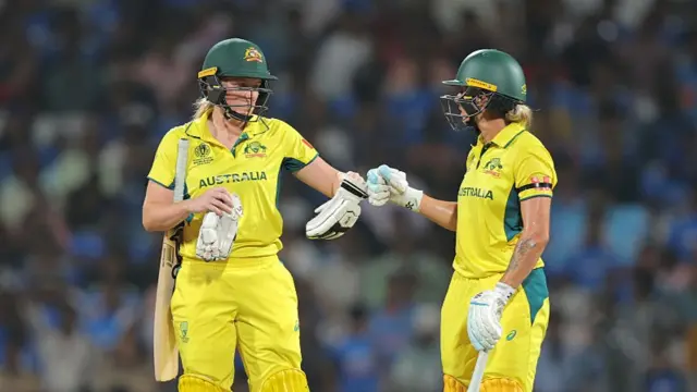 Kim Garth of Australia (L) touches gloves with team mate Ash Gardner