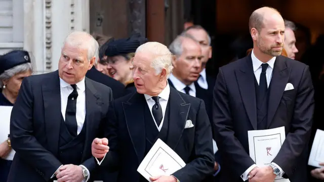 Andrew, Charles and William stand in dark suits next to each other.