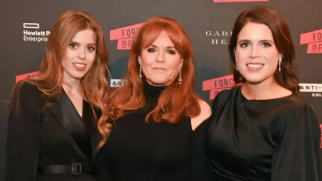 Beatrice, Sarah and Eugenie smile as they pose for a photo at a social event in London.