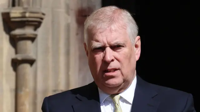 Close up of Andrew Mountbatten Windsor in black suit and pastel green tie outside of St George's Chapel in Windsor