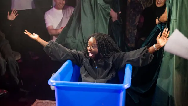 Minah Shannon bursts out of a blue tub.