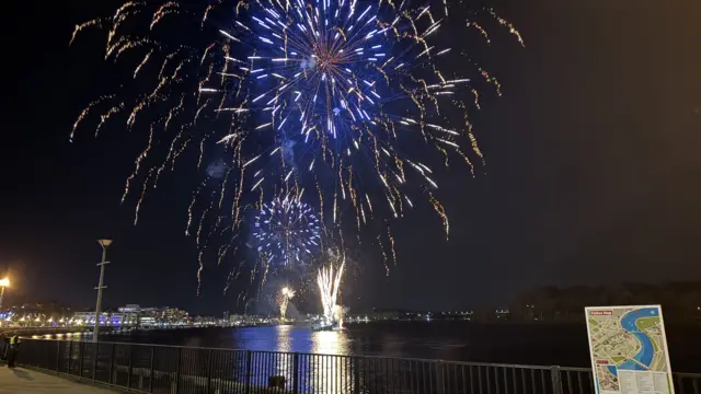 Fireworks igniting over the water