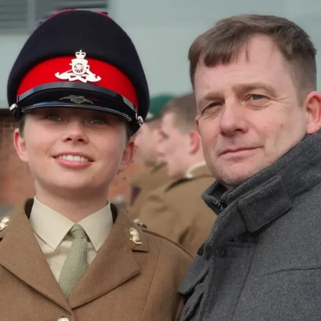 Jaysley Beck on passing out with father Anthony. She is wearing her brown military uniform and a muted green shirt and tie.