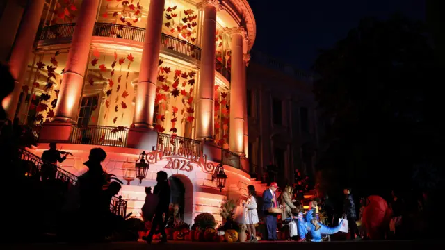 A wide picture of the White House lit up with Halloween decorations