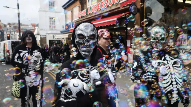Young people in Whitby England, stand on a street wearing costumes.