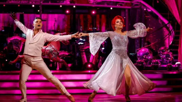 La Voix and  Aljaž Škorjanec dancing in pink on the Strictly ballroom in week one