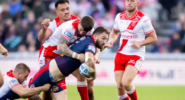 St Helens' Daryl Clark is tackled by Hull KR's Oliver Gildart.