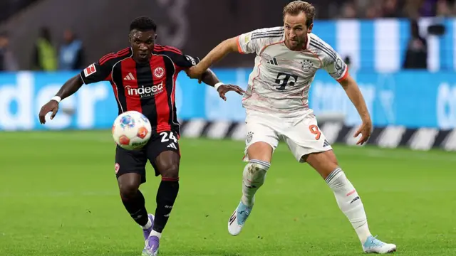 Buta of Eintracht Frankfurt and Harry Kane of Bayern Munich battle for possession