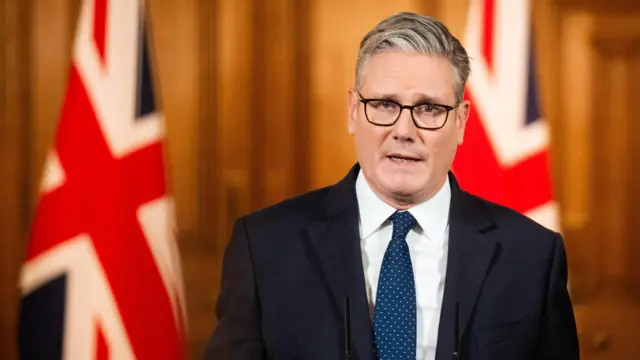 Keir Starmer in front of two UK flags