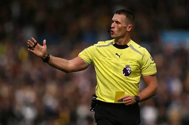 Referee holding yellow card