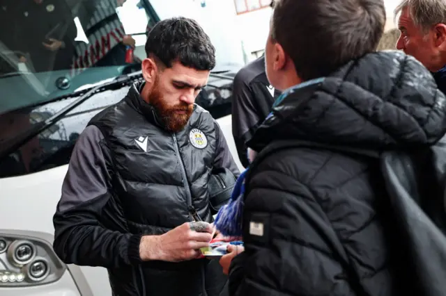 Liam Donnelly signs an autograph for a young fan