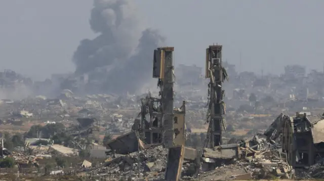 Smoke rises above decimated buildings in Gaza City