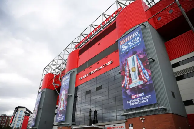 A shot of the Sir Alex Ferguson Stand at Old Trafford with two Super League posters draped down the sides