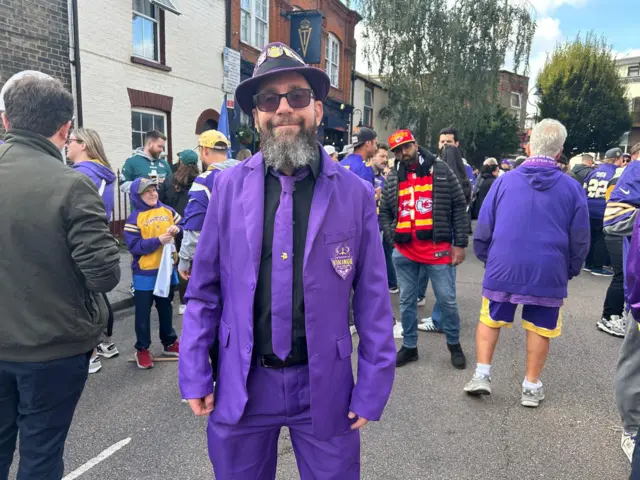 Minnesota Vikings fan John Macdonald, dressed in a purple suit, tie and top hat