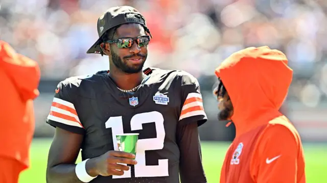 Shedeur Sanders talks to a team-mate on the sidelines during the Cleveland Browns' defeat by the Cincinnati Bengals