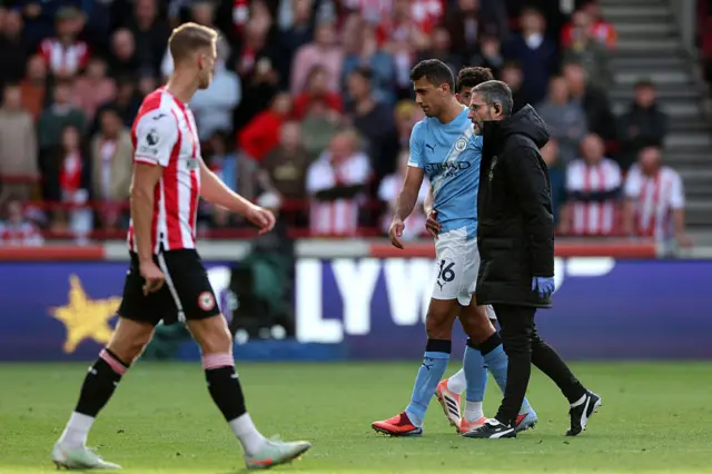 Rodri being walked off the pitch