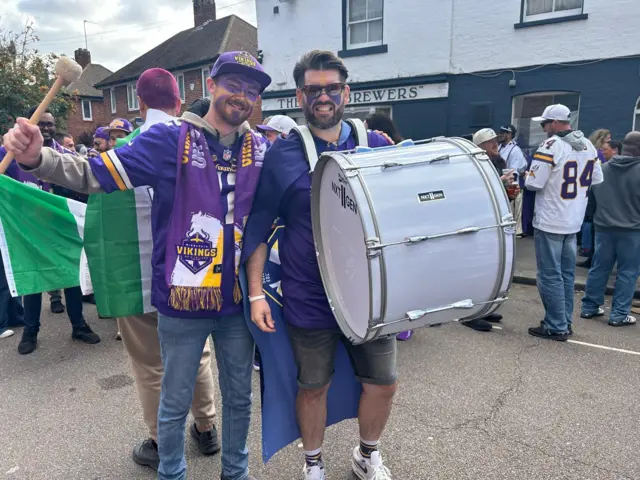Minnesota Vikings fans Reece Field [left] and Rich Dawson [right] holding a large drum and dressed Vikings merchandise