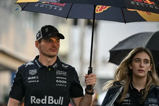 Max Verstappen holds an umbrella in the Singapore paddock