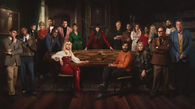 A photo of all the contestants of this year's Celebrity Traitors sat round the table