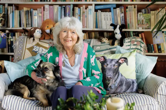 Jilly Cooper on a sofa with a dog