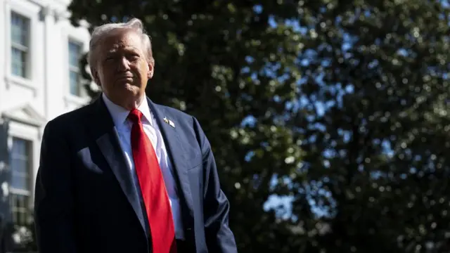 Donald Trump is seen walking in a blue suit and red tie