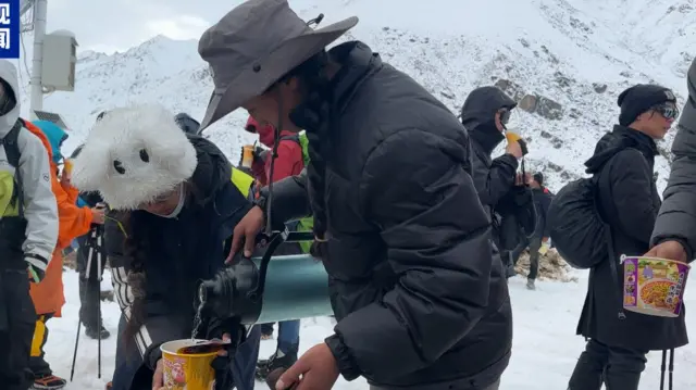 People can be seen preparing instant noodles as rescue operation continues