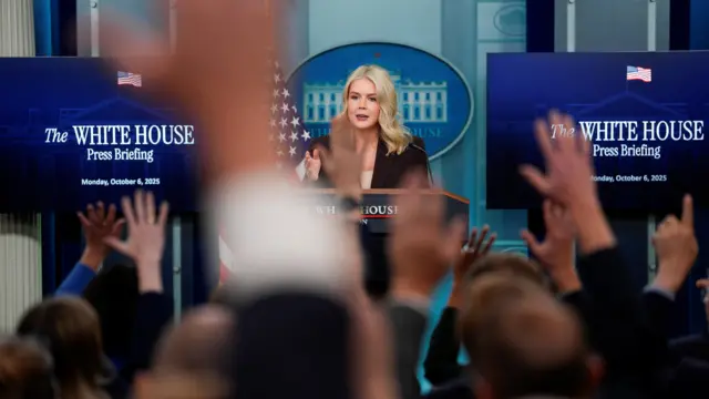 Reporters raise their hands to ask questions during a press briefing by White House Press Secretary Karoline Leavitt