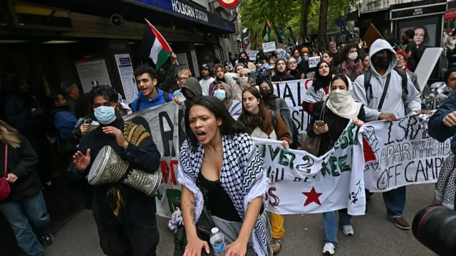 Pro-Palestinian student protesters walk behind banners during an inter-university march for Gaza in London on October 7.