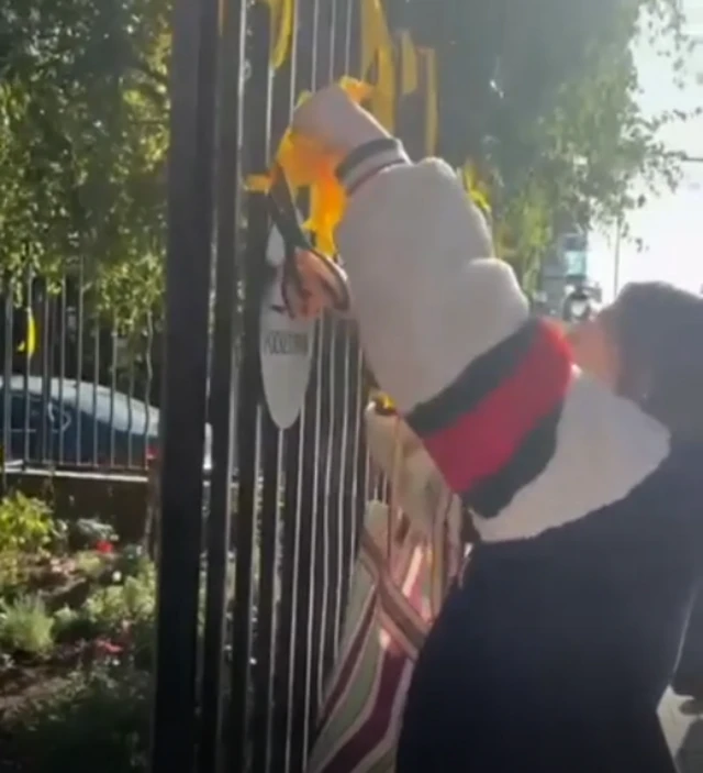 A woman cutting down yellow ribbons with a pair of scissors