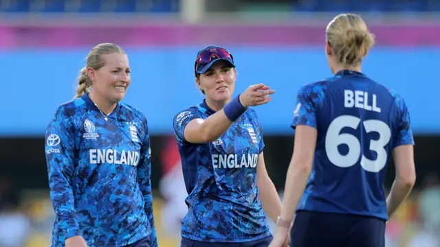Nat Sciver-Brunt of England (C) gestures as she speaks to team mates Sophie Ecclestone (L) and Lauren Bell