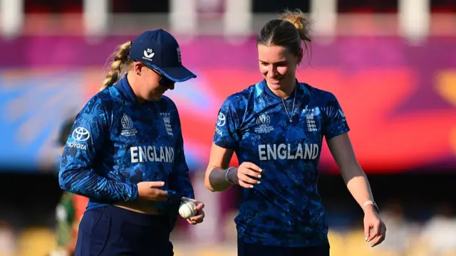 Lauren Bell of England (R) speaks to team mate Sophie Ecclestone