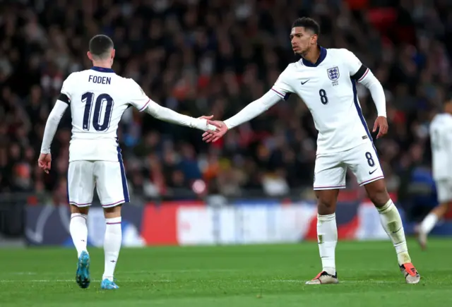 Phil Foden shaking hands with Jude Bellingham while playing for England