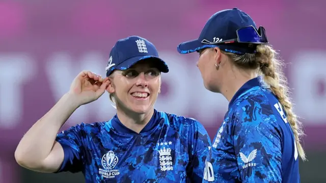 Heather Knight of England (L) speaks to team mate Sophie Ecclestone