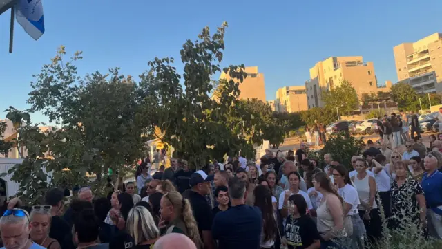 Several people standing at an event talking to one another