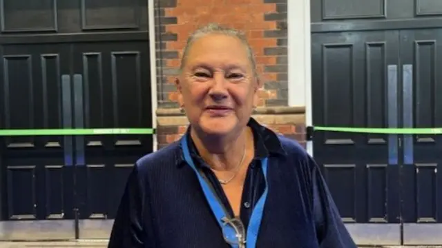 Janet Morley looks to camera, wearing a blue lanyard